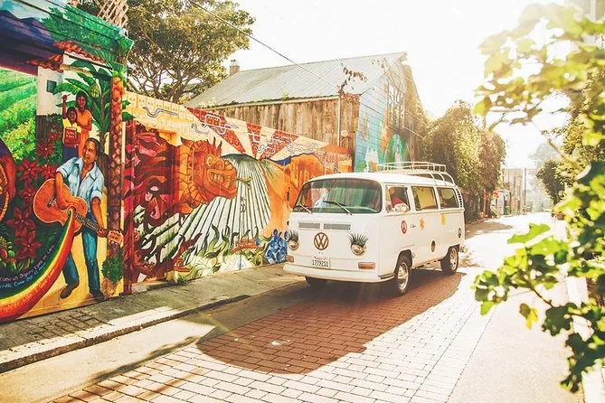 A vintage VW bus parked beside a colourful street mural