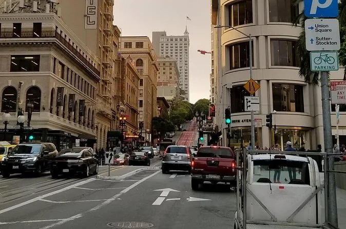 A downtown San Francisco street lined with buildings and parked cars